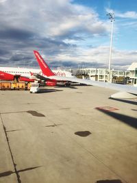 Airplane on airport runway against sky