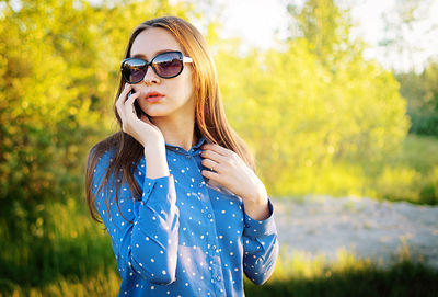 Young woman wearing sunglasses standing outdoors