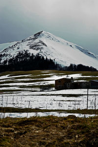 Scenic view of snow covered field against sky