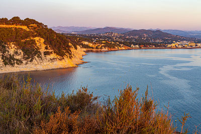 Scenic view of sea and mountains against sky