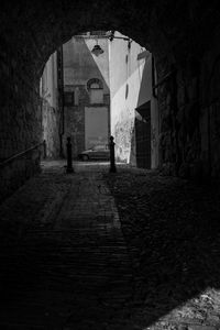 Woman walking on footpath by building