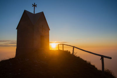 Silhouette built structure against sky during sunset