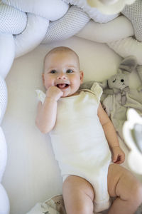 High angle view of cute baby girl lying on bed