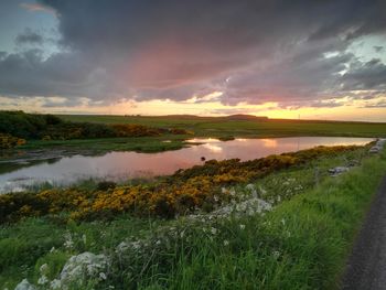 Scenic view of river against sky during sunset