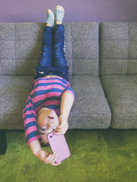 Full length of happy woman lying on sofa