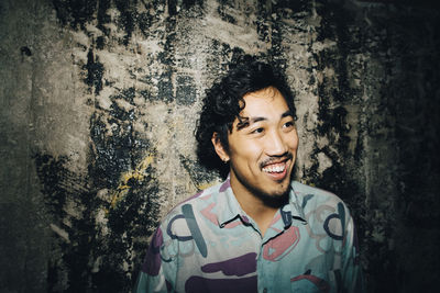 Portrait of smiling young man against wall