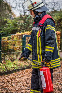 Firefighter holding fire extinguisher on field