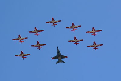 Low angle view of airshow against clear blue sky