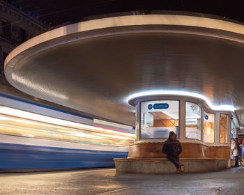 Rear view of woman walking at illuminated railroad station