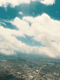 Aerial view of city against cloudy sky