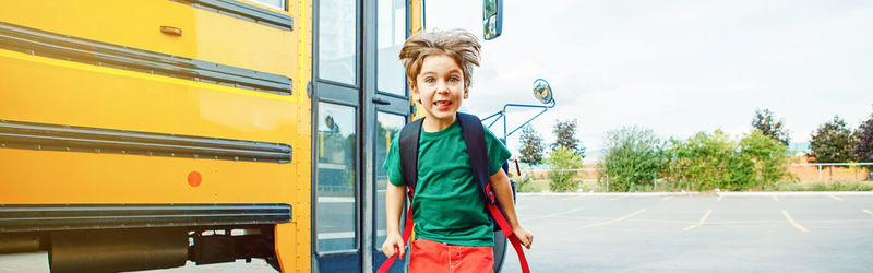 Portrait of cheerful boy jumping on road