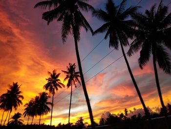 Low angle view of silhouette palm trees against romantic sky