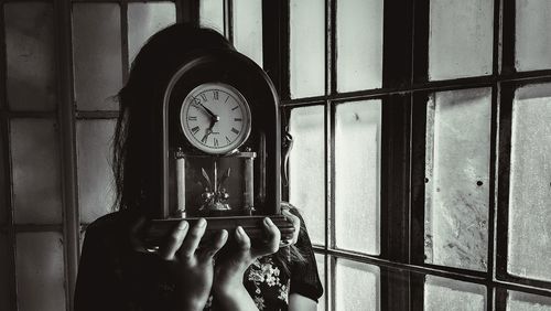 Midsection of person photographing through window at home