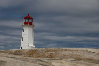 Lighthouse by sea against sky