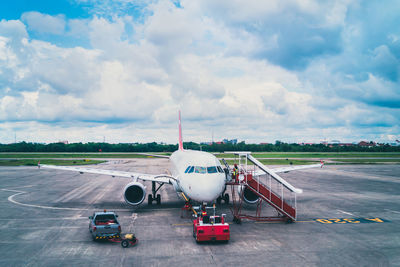 Airplane on runway against sky