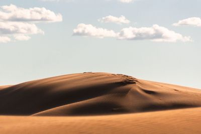 Sand dunes in desert against sky