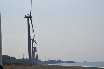 Wind turbines on land against sky