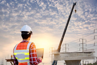 Rear view of man working against sky