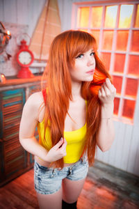 Portrait of beautiful redhead woman standing in room