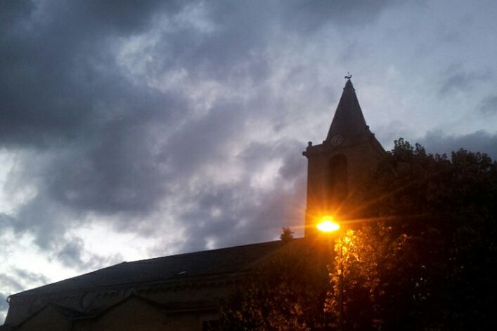 religion, building exterior, architecture, built structure, place of worship, spirituality, sky, church, low angle view, cloud - sky, sunset, cloudy, sun, cloud, cross, silhouette, outdoors, temple - building