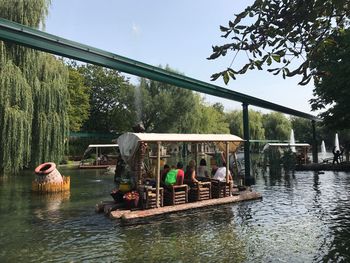 People on boat in lake against sky