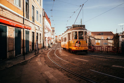 Train on railroad tracks in city against sky