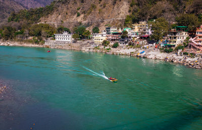 Ganges river flowing through mountains with city nestled at riverbank from top angle