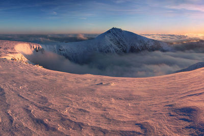 Scenic view of snowcapped mountains against sky during sunset