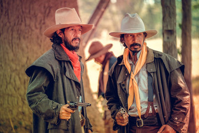 Cowboys with guns standing on land