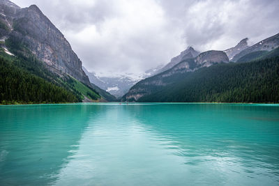 Scenic view of lake by mountains against sky