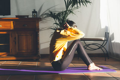 Young caucasian brunette woman doing exercises at home.