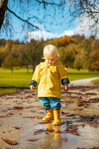 Full length of boy standing on puddle