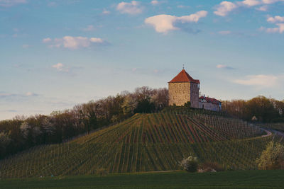 Building on field against sky