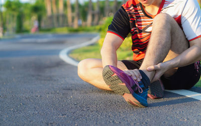 Low section of man sitting on road