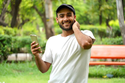 Young man using mobile phone while standing outdoors