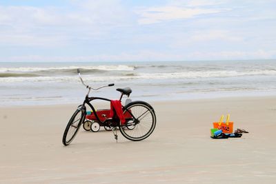 Bicycle on beach against sky