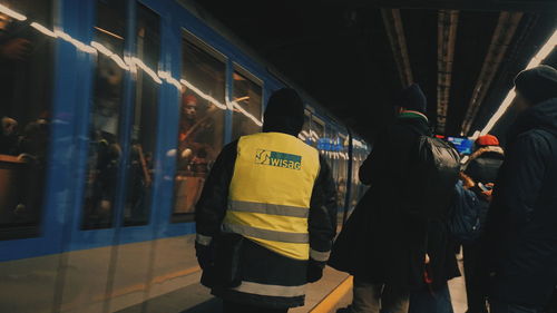 Rear view of people waiting at railroad station