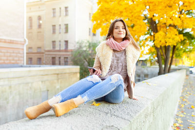 Portrait of smiling woman sitting in city