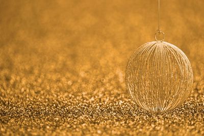Close-up of christmas ornament hanging over sequins