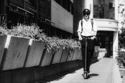 Electric transportation, electric scooter. businesswoman with helmet driving to work in the city.