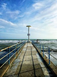 View of pier on sea against cloudy sky