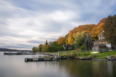 Scenic view of river by buildings against sky