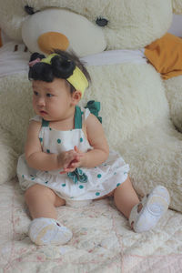 Cute baby girl lying on bed at home