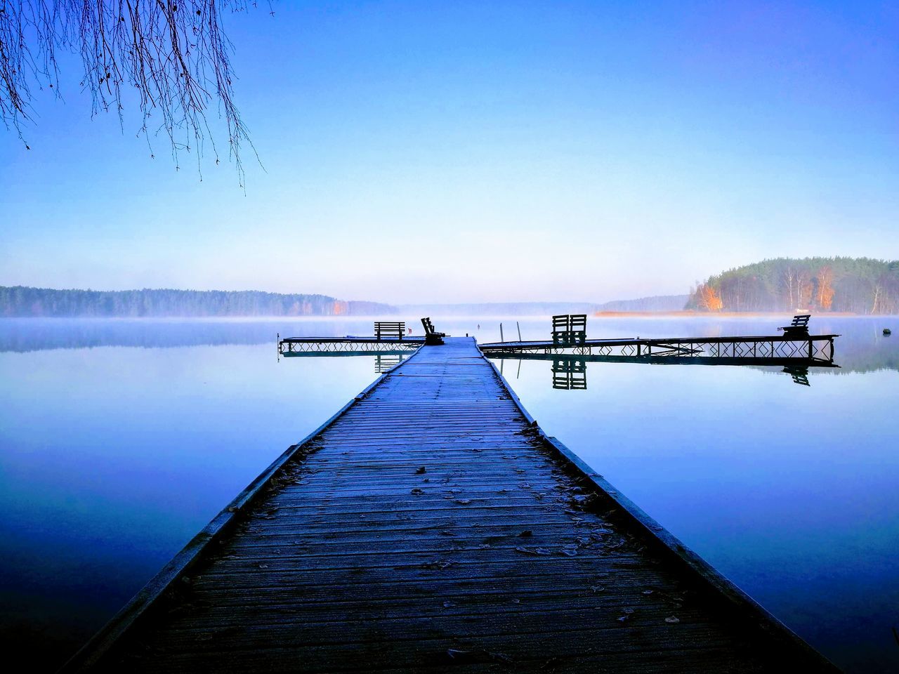 water, sky, pier, tranquil scene, nature, scenics - nature, the way forward, wood - material, beauty in nature, tranquility, lake, reflection, direction, no people, jetty, blue, clear sky, day, diminishing perspective, outdoors, long