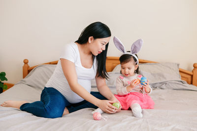 Mother and daughter sitting on floor