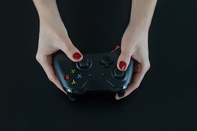 Midsection of woman holding camera against black background