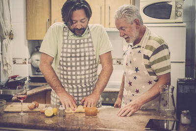 Father and son preparing food in kitchen