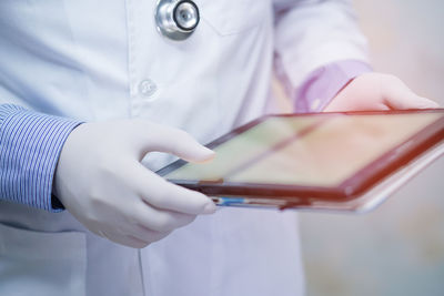 Midsection of man holding mobile phone