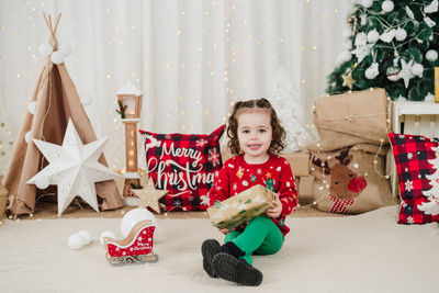 Portrait of siblings playing with christmas tree