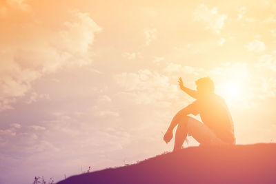 Low angle view of silhouette man standing against sky during sunset